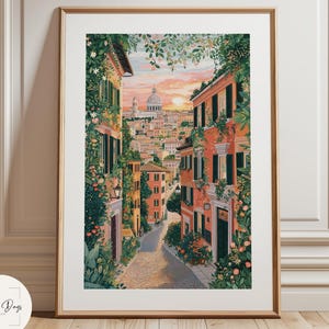 Puede incluir: Impresión artística enmarcada que representa una pintoresca escena de calle europea. La obra de arte muestra edificios en tonos naranja y rosa, con exuberante vegetación y un paisaje urbano distante bajo un cielo de atardecer. La impresión está enmarcada en madera.