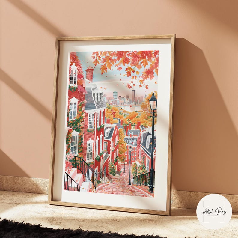 May include: Framed watercolor print of a charming cityscape with red brick buildings, lush greenery, and autumn foliage. A black lamppost stands on a cobblestone street, leading the eye towards a distant skyline. The artwork is set in a wooden frame.