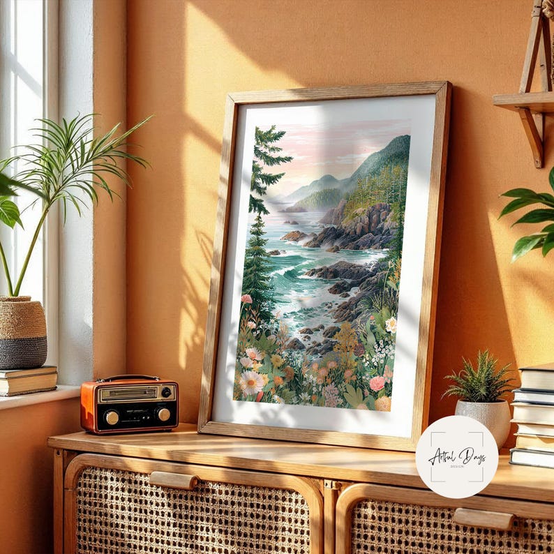 May include: A framed watercolor print of a coastal landscape with a wooden frame. The artwork depicts a rocky shoreline, turquoise water, and lush green hills. The print is displayed on a wooden cabinet with a vintage radio and a potted plant.