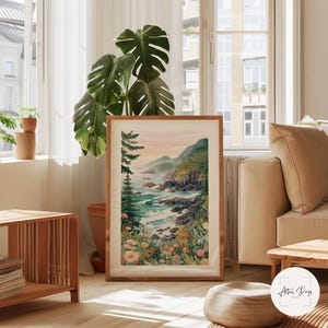 May include: A framed watercolor print of a coastal landscape. The artwork depicts a rocky shoreline, turquoise water, and lush greenery under a soft, pastel sky. The frame is made of light brown wood. The print is displayed in a well-lit room.