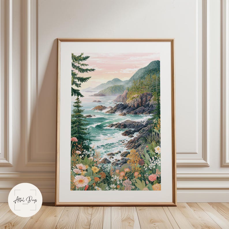 May include: A framed watercolor print of a coastal landscape. The artwork depicts a rocky shoreline with turquoise water, lush green mountains, and a soft pink and yellow sky. Wildflowers bloom in the foreground, and evergreen trees frame the scene.