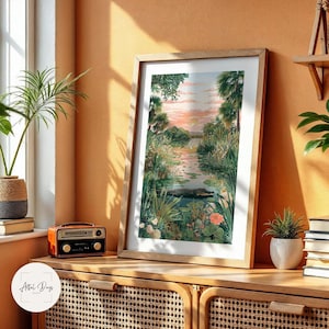 Puede incluir: Una impresi&oacute;n art&iacute;stica enmarcada que presenta un paisaje sereno con un r&iacute;o, exuberante vegetaci&oacute;n y un cielo al atardecer. La obra de arte incluye una representaci&oacute;n de un caim&aacute;n en el agua. La impresi&oacute;n se exhibe en un mueble de madera.