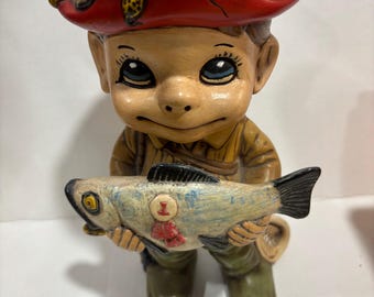 vintage ceramic figurine is identified as a 1st Place Bass fisherman statue, likely produced from an Atlantic Mold in the 1970s.