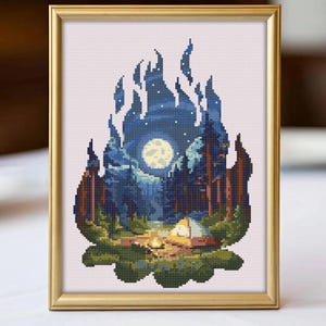 May include: Cross-stitch art framed in gold. The artwork depicts a nighttime camping scene with a campfire, tent, and forest under a full moon and starry sky. The color palette includes blues, greens, and browns.