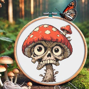 May include: A cross-stitch embroidery pattern of a cartoon mushroom with a skull face and large eyes. The mushroom is red with white spots and is on a white background.