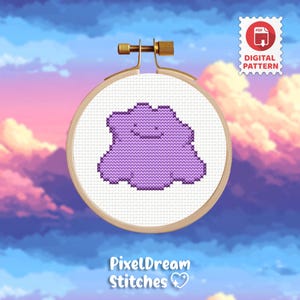 May include: A cross-stitch pattern in a wooden embroidery hoop featuring a purple, amorphous, blob-like creature with a simple smiling face on white fabric. A white badge in the top right corner displays a red PDF icon and the text DIGITAL PATTERN.