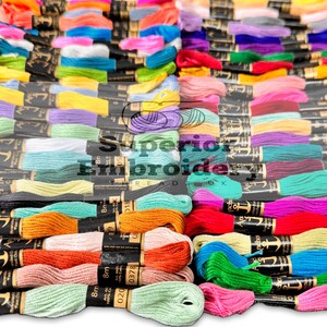 May include: A vibrant assortment of embroidery threads in a multitude of colours, from pinks and greens to blues and oranges. The threads are neatly bundled, with labels visible. The image features the text "Superior Embroidery Threads".