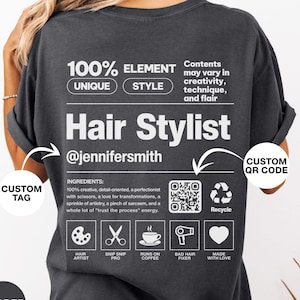 K&ouml;nnte beinhalten: Ein anthrazitfarbenes T-Shirt mit einer wei&szlig;en Grafik auf der R&uuml;ckseite, die einem Produktetikett &auml;hnelt. Der Text lautet 100% ELEMENT UNIQUE STYLE, Hair Stylist, @jennifersmith, inklusive Inhaltsstoffen, QR-Code und f&uuml;nf Symbolen.