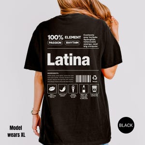 Może przedstawiać: Czarny t-shirt z napisem "Latina" dużymi białymi literami. Koszulka zawiera tekst i grafikę, w tym "100% Element" i ikony składnik&oacute;w. Modelka nosi rozmiar XL.