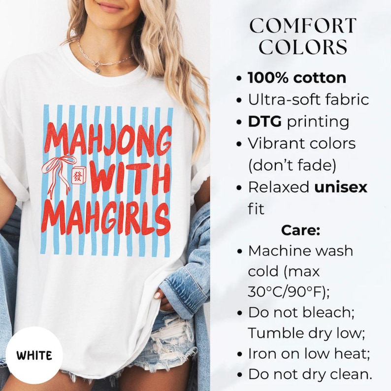 Peut inclure: Un t-shirt blanc avec un carr&eacute; &agrave; rayures verticales bleues portant le texte rouge MAHJONG WITH MAHGIRLS et une petite ic&ocirc;ne de tuile de mahjong rouge. Le t-shirt est en 100% coton, pr&eacute;sente une coupe d&eacute;contract&eacute;e et une impression DTG.