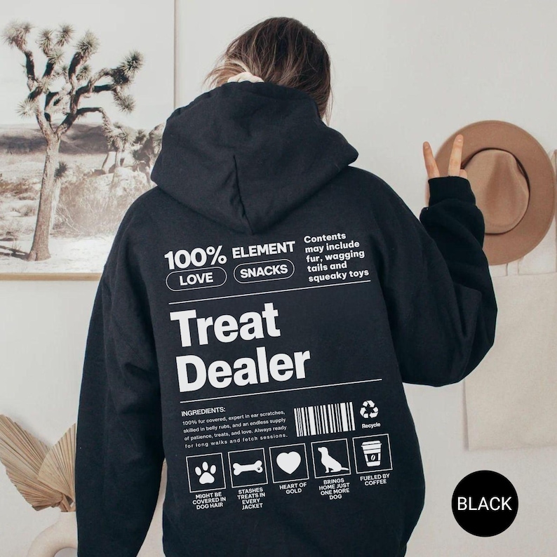 May include: Black hoodie with the text "Treat Dealer" and other text including "100% Love Snacks" and "Contents may include fur, wagging tails and squeaky toys". The hoodie has a hood and a kangaroo pocket.