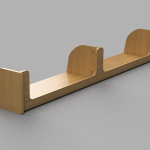 May include: A light-coloured wooden bookshelf with a minimalist design. The shelf has a long, flat base with three curved dividers, creating four sections. The wood has a smooth, polished finish.