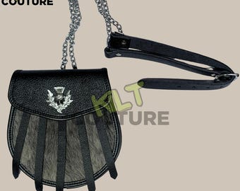 May include: A black leather sporran with a silver thistle emblem and a fringe of gray fur. The sporran has a black leather strap and a silver chain.