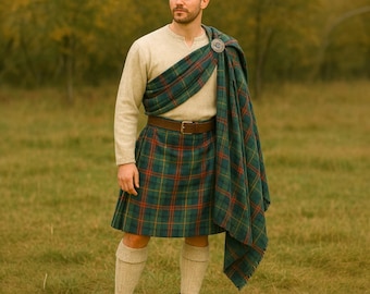 May include: A person in traditional Scottish attire, featuring a green, red, and yellow plaid kilt and shawl. The outfit includes a beige long-sleeved shirt, brown belt, knee-high socks, and brown boots, set against a grassy backdrop.