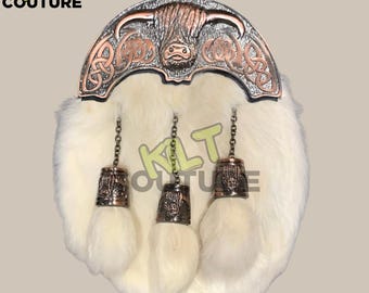 May include: White faux fur kilt sporran with a silver and copper Celtic knot design and a Highland cow head. The sporran has three tassels with silver bells.