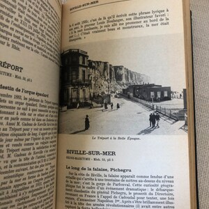 K&ouml;nnte beinhalten: Ein offenes Buch mit Text und einer Schwarz-Wei&szlig;-Fotografie einer K&uuml;stenlandschaft. Das Foto zeigt Geb&auml;ude, Klippen und Menschen. Der Text ist auf Franz&ouml;sisch.