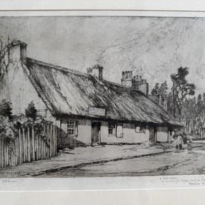 May include: Black and white etching of Burns' Cottage, a thatched-roof building with a sign above the door. The artwork includes a fence, trees, and a street scene. The artist's signature and date are visible.