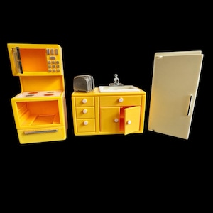 May include: A yellow toy kitchen set with a microwave oven, stove, sink, and refrigerator. The microwave oven has a digital display. The sink has a chrome faucet. The refrigerator is off-white.