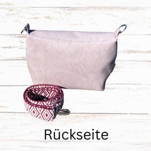 May include: A pale pink handbag with a floral embossed pattern, and a patterned strap. The strap is white and burgundy with a geometric design. The word "R&uuml;ckseite" is printed at the bottom of the image.