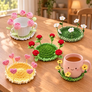 Puede incluir: Cuatro posavasos redondos de ganchillo con motivos florales y de corazón en tres dimensiones. Un posavasos blanco tiene flores rosas, uno verde tiene margaritas blancas, uno verde tiene rosas rojas, uno amarillo tiene corazones rosas y uno verde tiene flores amarillas.