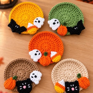 Pode incluir: Cinco bases para copos redondas de crochê nas cores amarela, verde, laranja, marrom e bege. Cada base apresenta pequenas aplicações de crochê com tema de Halloween, incluindo fantasmas brancos, morcegos pretos, gatos pretos, abóboras laranjas e doces de milho.