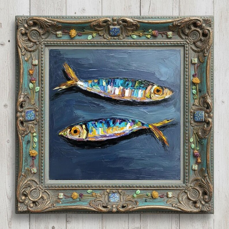 May include: An oil painting of two fish with iridescent blue, yellow, and silver scales swimming against a dark navy blue background. The artwork is encased in an ornate, weathered teal and gold frame decorated with small floral and tile accents.