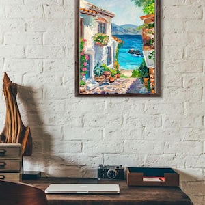 May include: A framed oil painting depicting a coastal Mediterranean scene with a white stucco building, vibrant potted flowers, a stone pathway, and a bright blue sea under a clear sky, rendered with visible brushstrokes and rich textures.