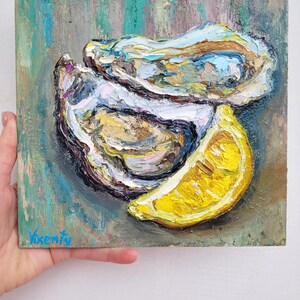 A still life painting of two oysters and a lemon wedge on a textured green background. The oysters are open and the lemon is sliced. The painting is signed "Vikenty" in the bottom left corner.