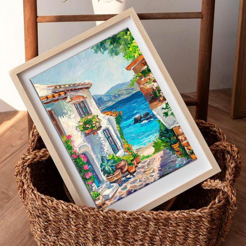 May include: An oil painting in a light wood frame depicting a coastal scene with a white building, vibrant pink and green flowers, a stone path, and a bright blue sea under a clear sky, rendered with thick, visible brushstrokes and texture.