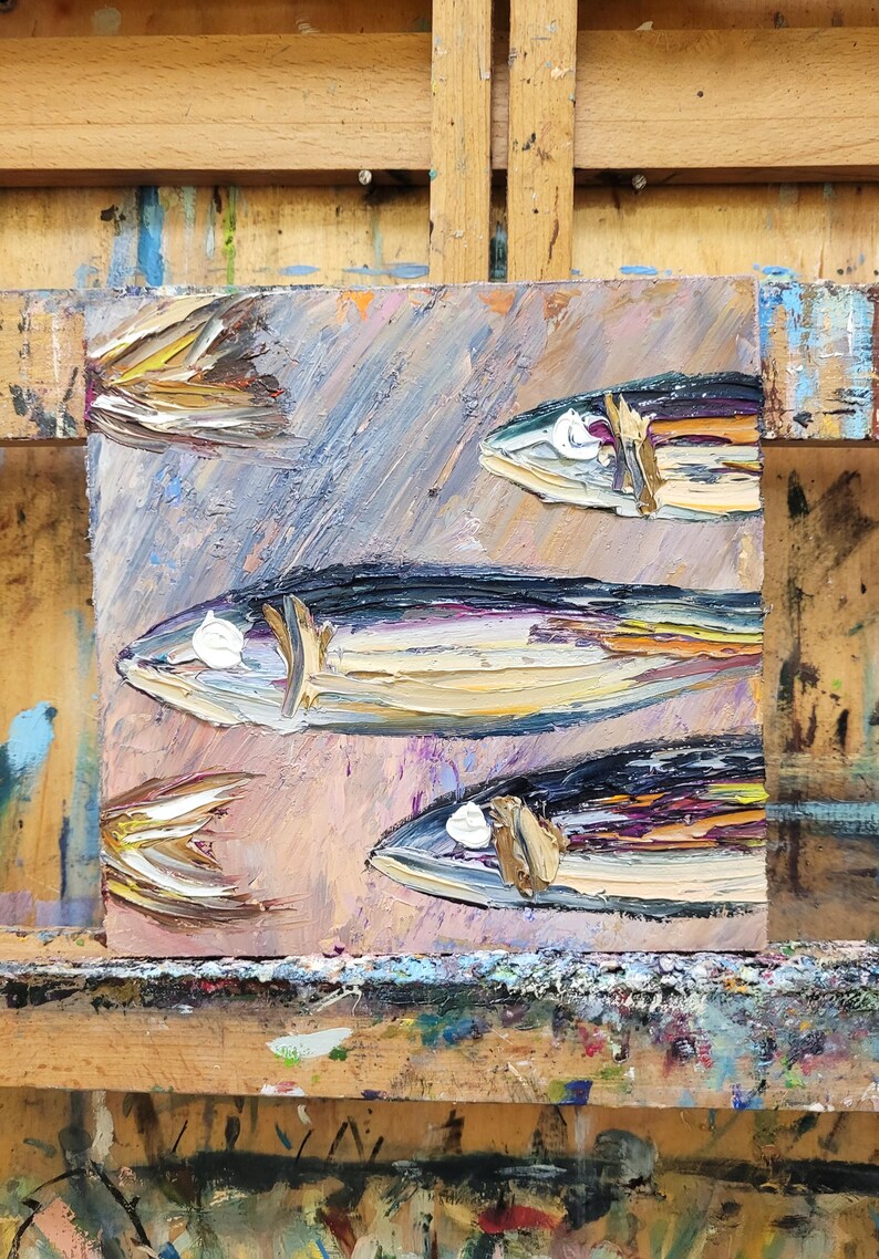 May include: Oil painting of several fish with textured brushstrokes. The fish are painted in shades of blue, yellow, and brown, with white highlights. The background is a blend of pink, blue, and purple hues.