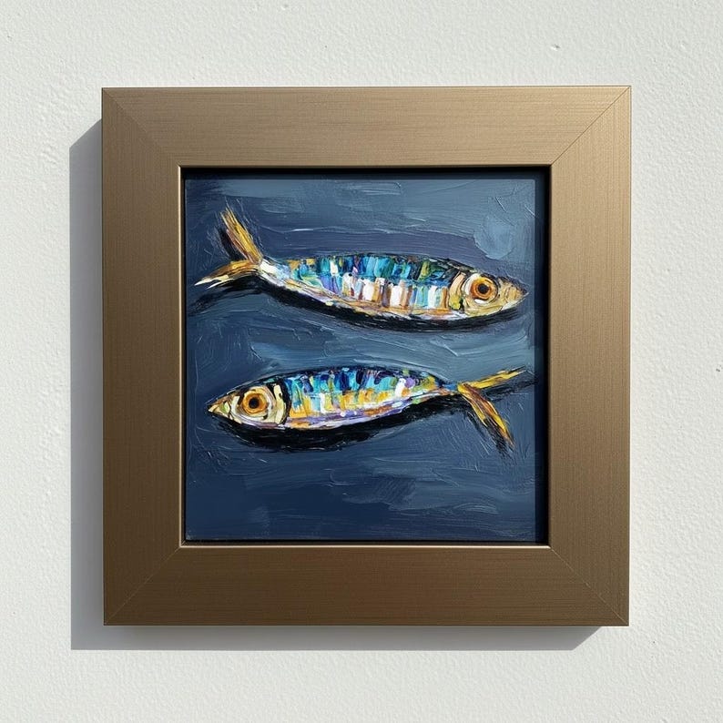 An oil painting of two fish in a dark blue sea. The fish are painted with bright colors, including yellow, blue, and white. The painting is framed in a gold-colored frame.