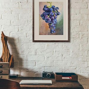 May include: A framed wall art print featuring an oil painting of a cluster of dark purple grapes with green stems. The artwork is rendered in a painterly style with visible brushstrokes, set against a soft, muted background of blended earth tones.