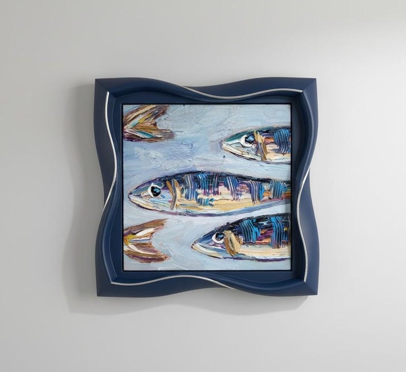 May include: An oil painting of several fish in shades of blue, yellow, and brown, set against a light blue background. The artwork is framed in a navy blue, wavy-edged frame with a silver inner border. The painting has a textured, impressionistic style.