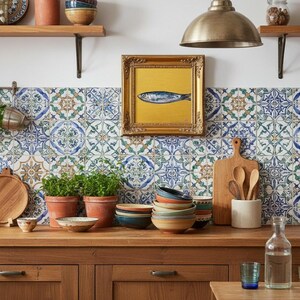 May include: A kitchen scene with a wooden countertop and cabinets. There are terracotta pots with plants, a framed fish painting, and a stack of colorful bowls. A cutting board and utensils are also visible.