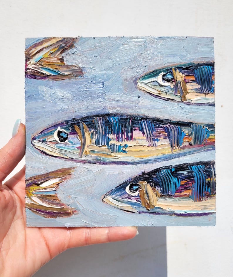 A painting of three fish on a blue background. The fish are painted in a realistic style with details of their scales and fins. The fish are arranged in a vertical line, with the largest fish at the top and the smallest fish at the bottom.