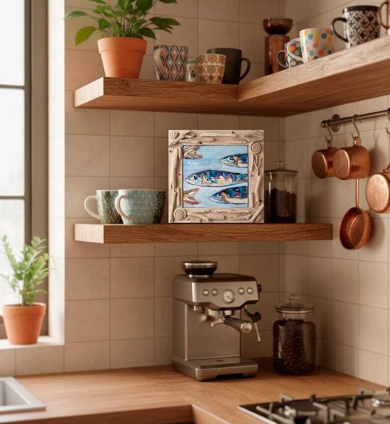 May include: A kitchen scene featuring wooden shelves with mugs, a framed fish painting, and copper pots. A silver espresso machine sits on the counter, with a glass jar of coffee beans. Plants in terracotta pots add a touch of greenery.