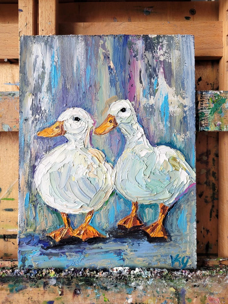 Oil painting of two white ducks with orange beaks and feet. The ducks are painted with thick brushstrokes, giving them a textured appearance. The background is a blend of blue, purple, and white vertical strokes.