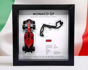 May include: A framed print of a red Formula 1 race car with a black track map of the Monaco Grand Prix. The print includes the date "26 May 2024" and the text "Monaco GP".