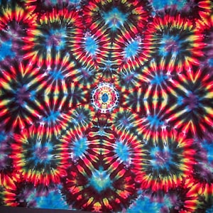 May include: A colorful tie-dye pattern with a central mandala design in shades of red, yellow, blue, and black.