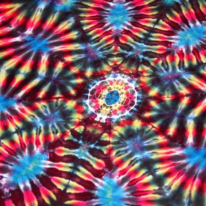 May include: A colorful tie-dye pattern with a central circle in shades of red, yellow, blue, and white. The background is a dark blue with swirls of red, yellow, and blue.
