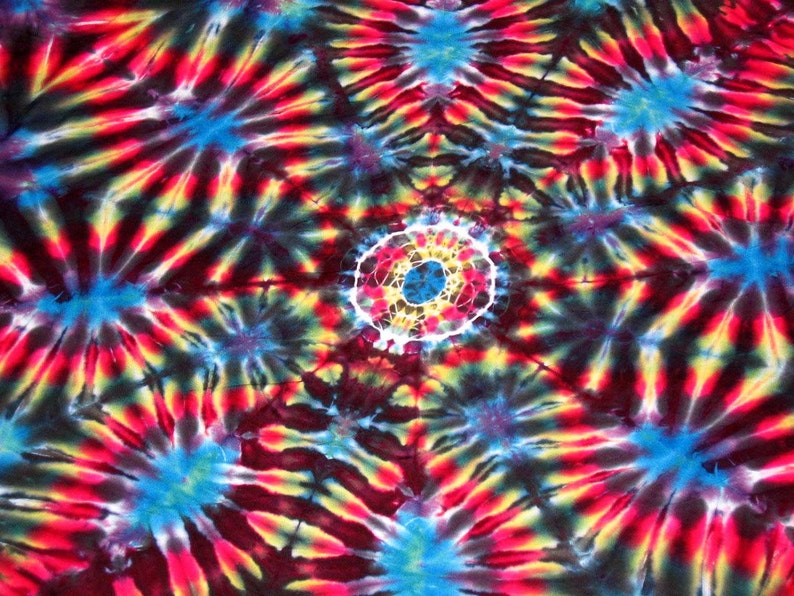 May include: A colorful tie-dye pattern with a central circle in shades of red, yellow, blue, and white. The background is a dark blue with swirls of red, yellow, and blue.