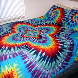 May include: A tie-dye bedspread featuring a large, colourful swirl pattern in shades of blue, purple, red, yellow, and green. The bedspread is made from soft, comfortable fabric and is ideal for adding a touch of colour and personality to any bedroom.