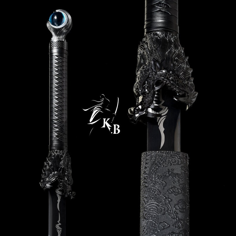 Może przedstawiać: Czarny miecz katana z rękojeścią w kształcie głowy smoka i niebieskim okiem na jelec. Miecz jest owinięty w czarną tkaninę z ozdobnym wzorem.