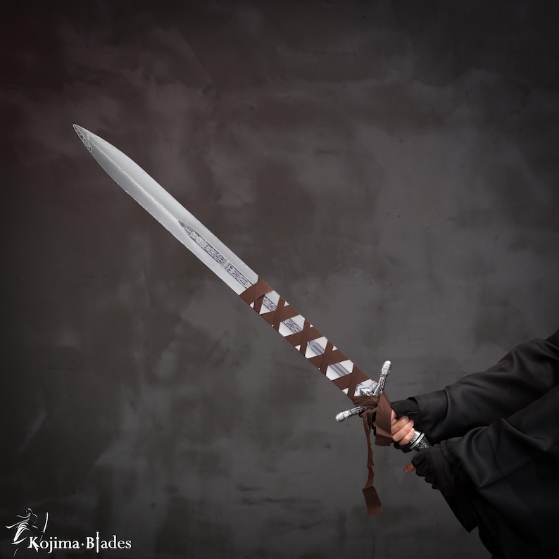 May include: A silver sword with a brown leather wrap on the handle. The sword is held by a person wearing a black jacket.