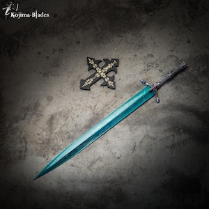 May include: A teal-colored sword with a black handle and a silver cross guard. The sword is lying on a gray surface with a black cross with gold accents in the background. The text "Kojima Blades" is visible in the top left corner of the image.