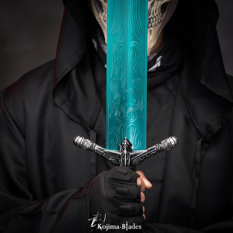 May include: A person wearing a black hooded cloak holds a teal-colored sword with silver accents. The sword has a detailed design on the blade.