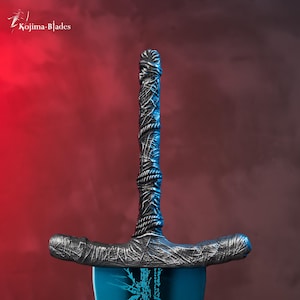 Op de afbeelding: Een close-up van het handvat van een zilveren zwaard met een blauw lemmet. Het handvat is gewikkeld in een getextureerd materiaal en heeft een donkergrijze afwerking.