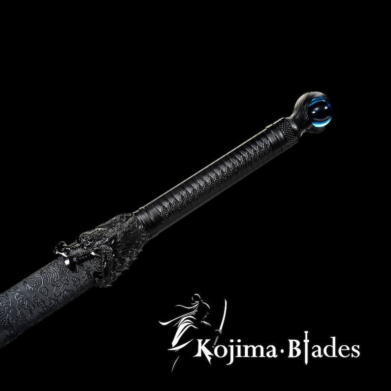 Może przedstawiać: Czarny miecz katana z głową smoka na rękojeści i niebieską szklaną kulą na końcu. Miecz jest ozdobiony skomplikowanymi wzorami.