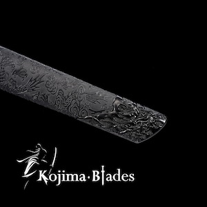 May include: Close-up of a black katana scabbard with an intricate dragon design. The scabbard is made of metal and has a textured finish.
