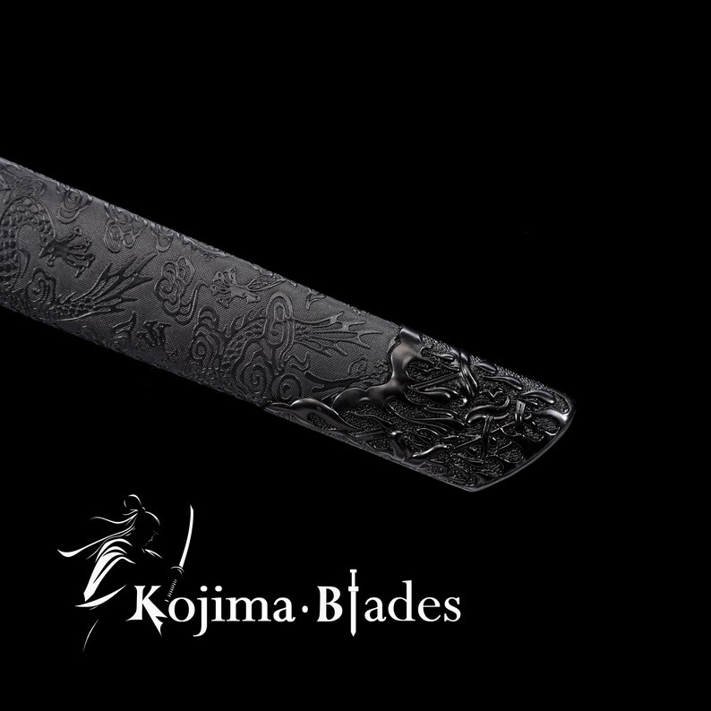 May include: Close-up of a black katana scabbard with an intricate dragon design. The scabbard is made of metal and has a textured finish.